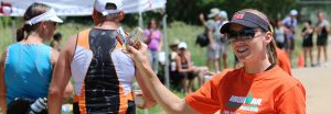 krista holding gels at triathlon aid station