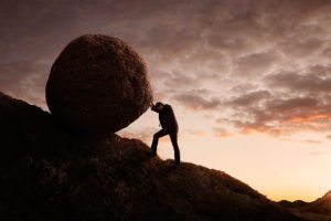 pushing boulder up a mountain